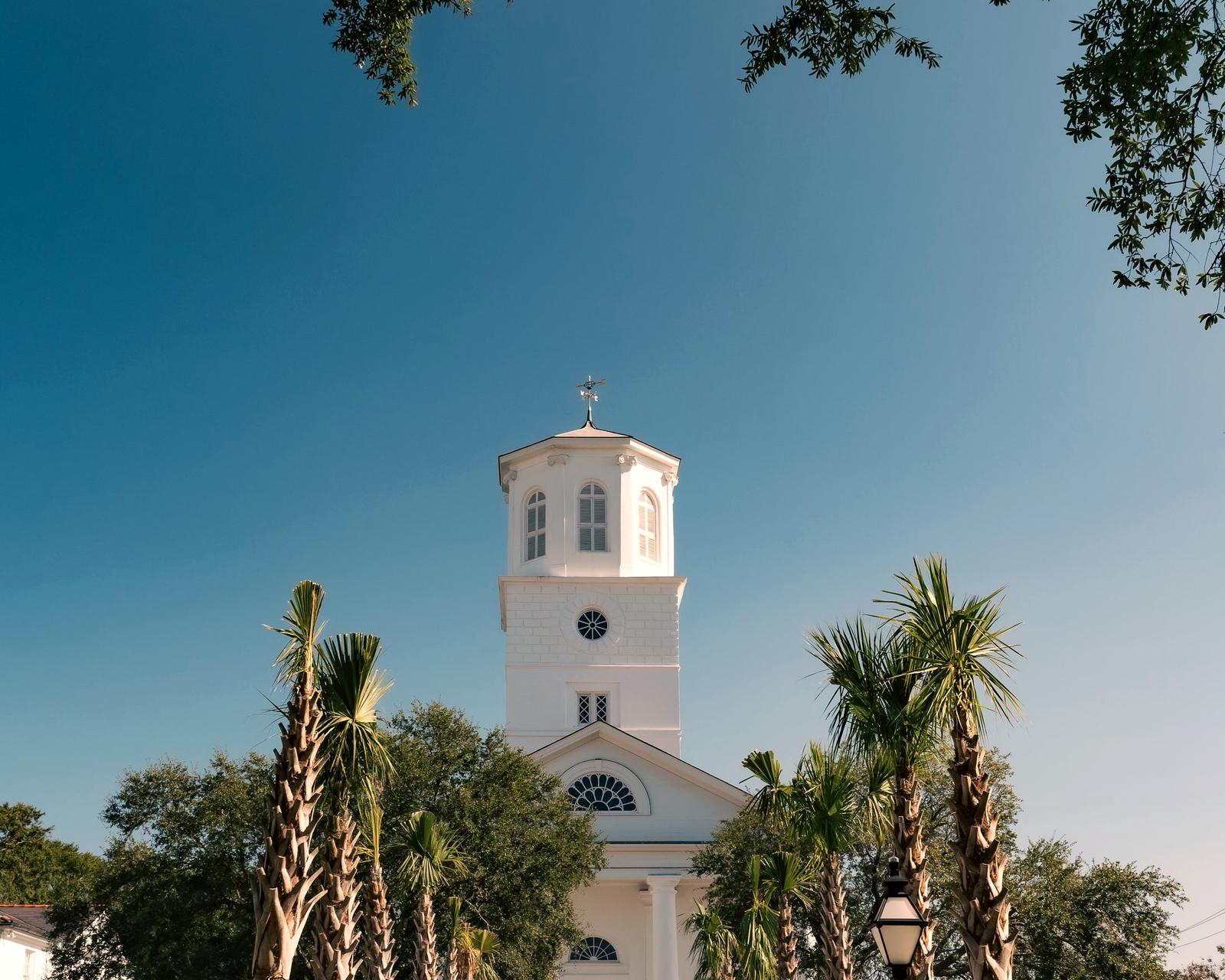 A white church framed by palm trees